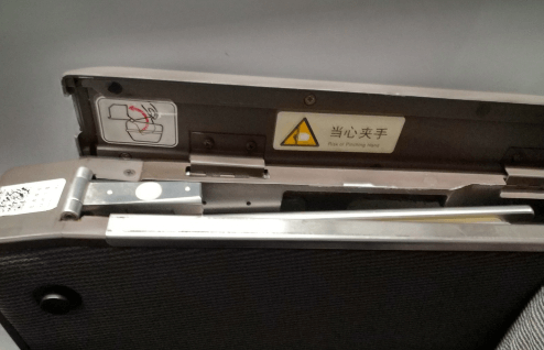 開蓋后可以看到一塊金屬板，這個就是藏起來的高鐵小桌板，向上將其拉出。
